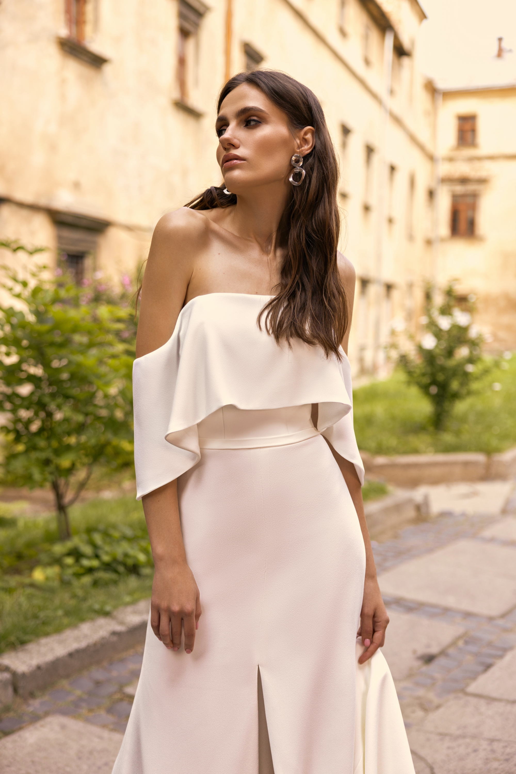 Brautkleid Nizhna 2311 aus körnigem Crêpe mit umgeschlagenem Bardot-Kragen und Schlitz vorn
